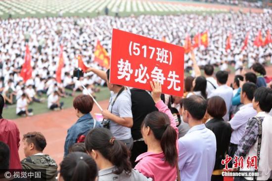 资料图：河北省衡水市第二中学2017级高一新生举行军训会操表演，家长们精心制作多种标牌、标语为孩子军训会操表演加油。 图片来源：视觉中国