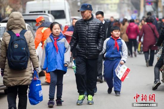 资料图：各地中小学陆续开学，学子们重返学堂开始新学期的课程。图为一名老人接送孩子放学。 张云 摄